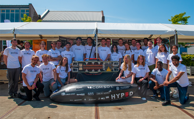 Photograph of group of team members from HYPED holding Hyperloop pod prototype
