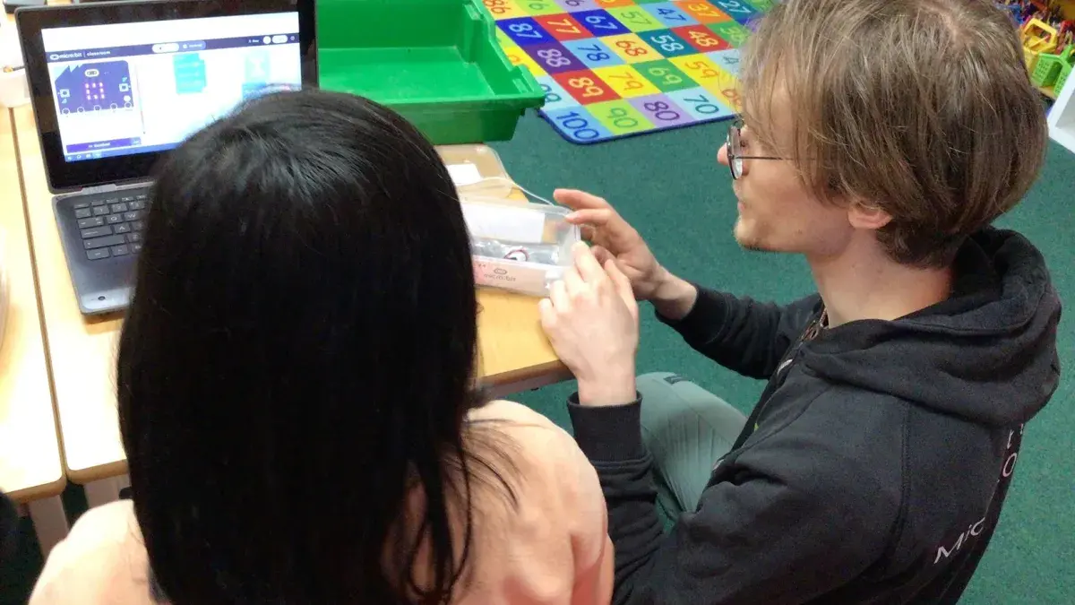A photo of a child and an adult in front if the laptop screen