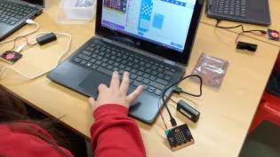 Photo of a child's hand on a laptop keyboard