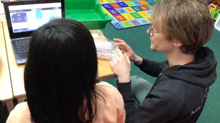 A photo of a child and an adult in front if the laptop screen