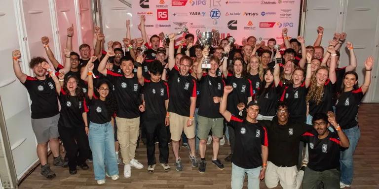 Group of people raising their hands and celebrating with trophies