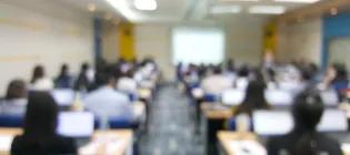 A blurred photo of a teaching room, taken from the back of the room