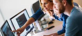 Two people in front of the screen. A woman pointing something on the screen