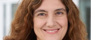 a photo of a smiling woman with curly brown hair
