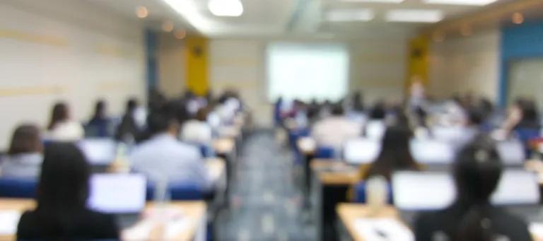 A blurred photo of a teaching room, taken from the back of the room