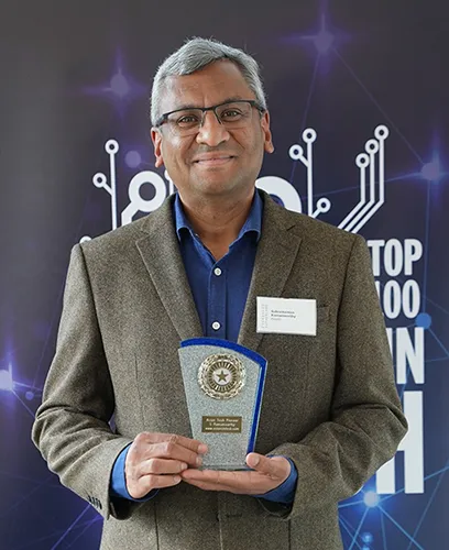 Photo of Ram Ramamoorthy holding trophy for Top 100 Asian Stars in UK Tech