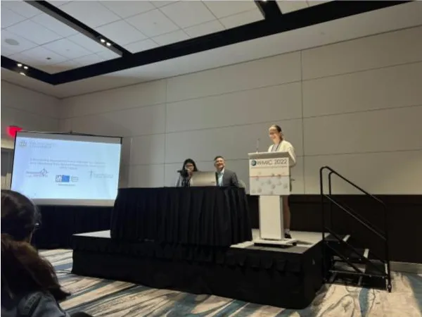 Picture of Alex at the speaker stand in the conference venue