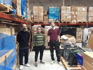 Three people masked in a warehouse