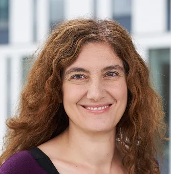 a photo of a smiling woman with curly brown hair