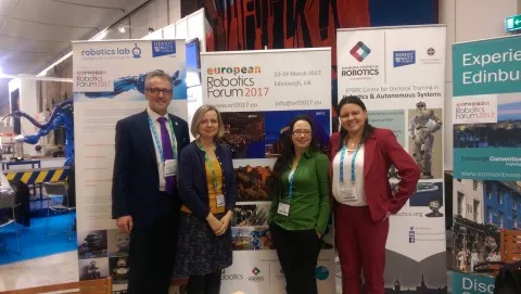 Image of people in from of advertising boards