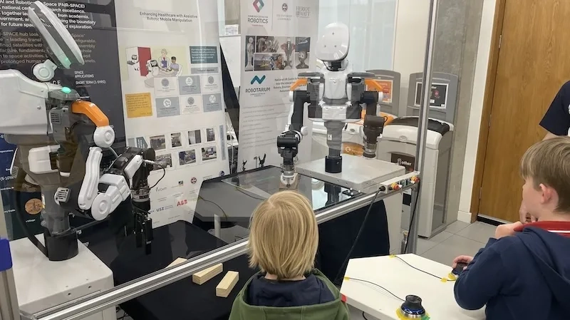 Children tele operating a robot to push a box
