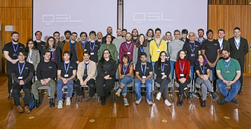 A group of people sitting and standing in rows, looking straight into the camera