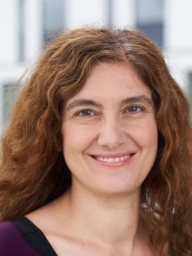 a photo of a smiling woman with curly brown hair