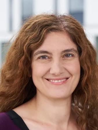 a photo of a smiling woman with curly brown hair